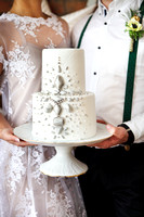 Cheerful married couple holding wedding cake